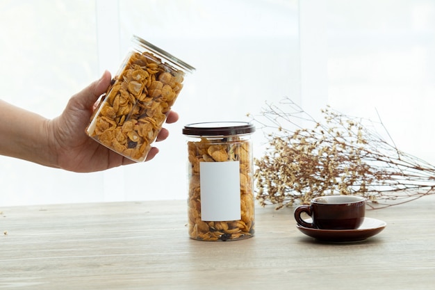 Foto asiatische süße und salzige snacks leckerer gemischter cornflakes-mockup-aufkleber für das logo mit einer tasse tee