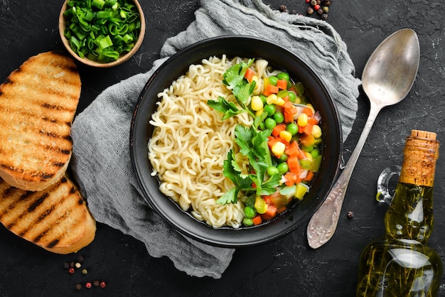 Asiatische Suppe mit Nudeln und Gemüse in einer Schüssel mit Toastbrot Diätkost Draufsicht Freier Kopierplatz