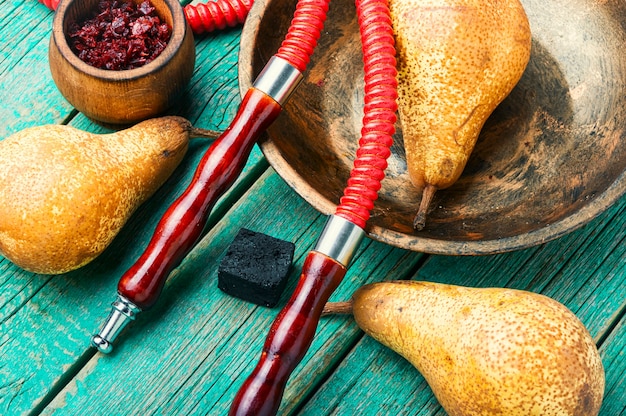 Asiatische Tabak-Shisha. Orientalisches Rauchen von Shisha mit Tabak. Fruchttabak mit Birne. Shisha-Rauchkonzept