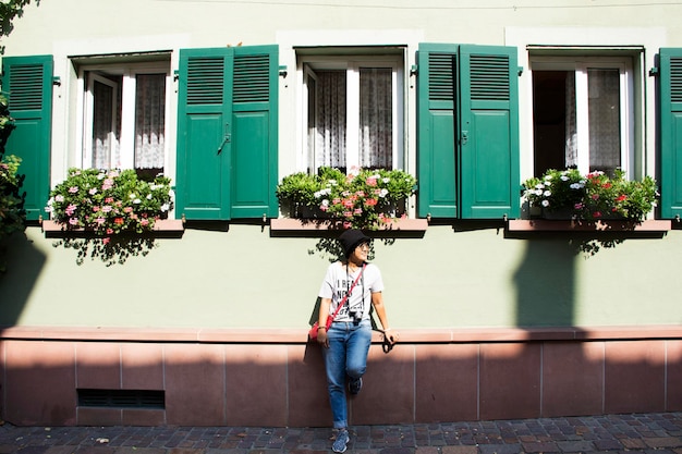 Asiatische thailändische Frauen posieren für ein Foto mit klassischem Retro-Vintage-Fenster an der Hauswand in der Stadt Ladenburg in Baden-Württemberg Deutschland