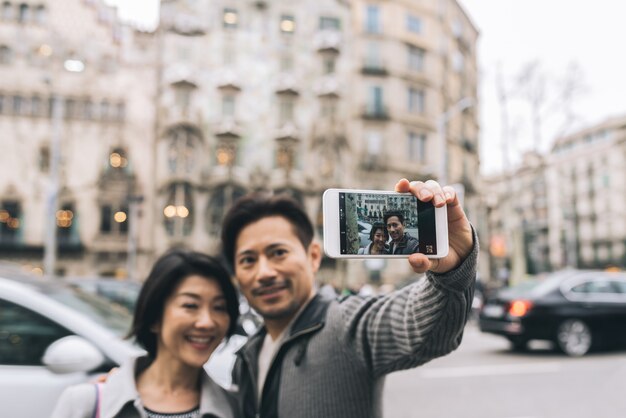 Asiatische touristische Paare, die ein selfie mit einem Handy nehmen