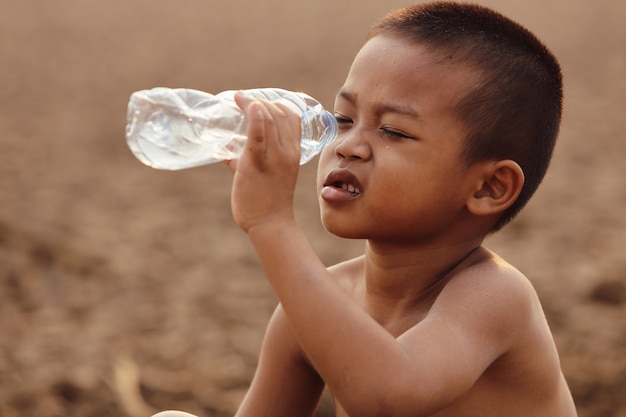 Foto asiatischen jungen fehlt derzeit sauberes wasser zum verzehr.