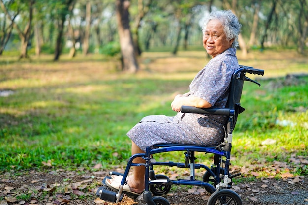 Asiatischer älterer oder älterer Frauenpatient alter Dame auf Rollstuhl im Park