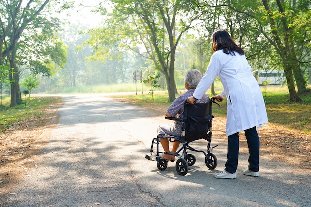 Asiatischer älterer oder älterer Frauenpatient alter Dame der Doktorhilfe und -sorgfalt, der auf Rollstuhl sitzt