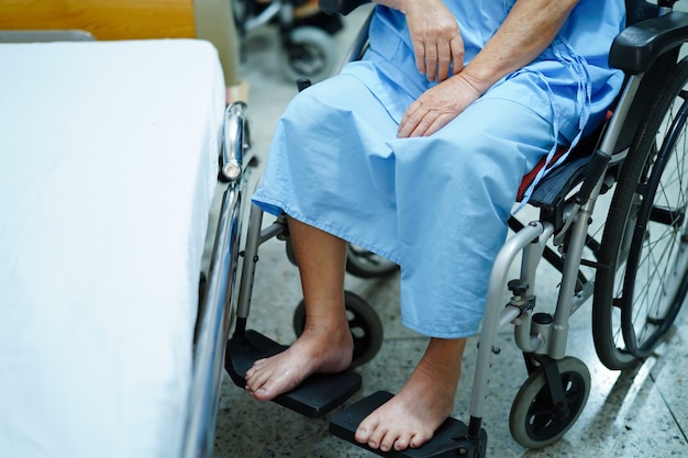 Asiatischer älterer oder älterer fraupatient, der auf rollstuhl im krankenhaus sitzt