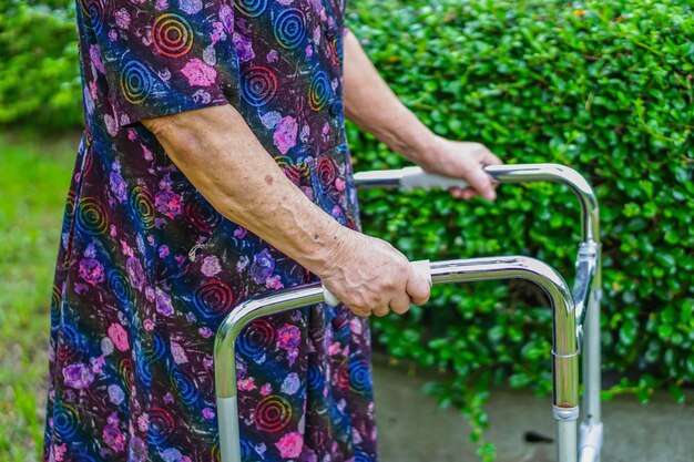 Asiatischer älterer oder älterer Gebrauchswanderer alter Dame mit starker Gesundheit beim Gehen am Park.