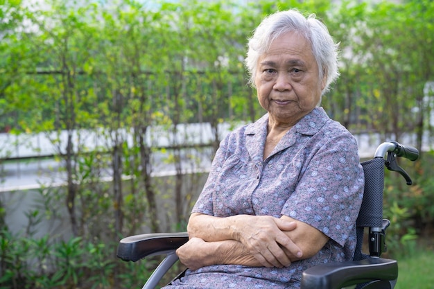 Asiatischer älterer oder älterer Patient der alten Dame im Rollstuhl im Park, gesundes starkes medizinisches Konzept.