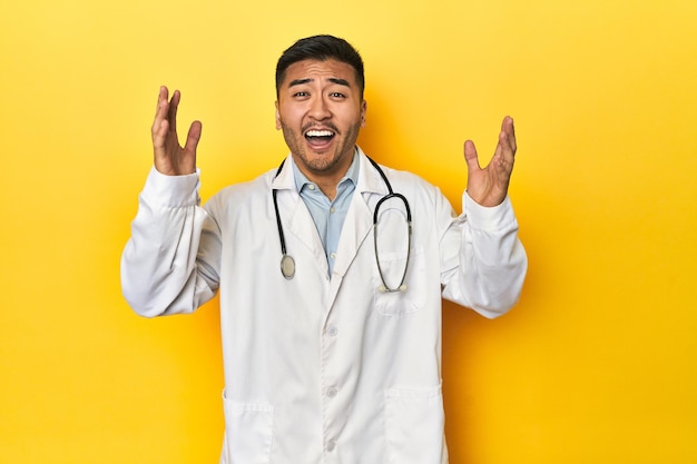 Asiatischer Arzt erhält eine angenehme Überraschung aufgeregt und hebt die Hände