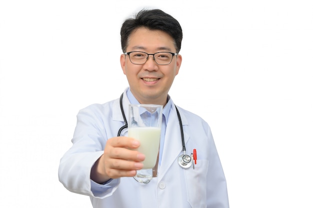 Asiatischer Arzt mittleren Alters trinkt ein Glas frische Milch auf einem weißen