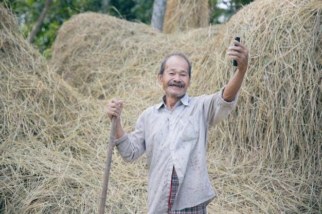 asiatischer Bauer des alten Mannes mit Handy