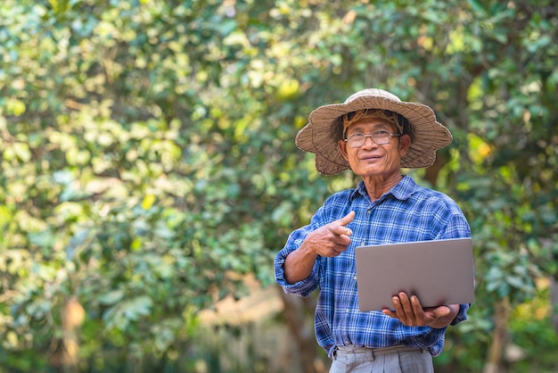 Asiatischer Bauer mit Laptop