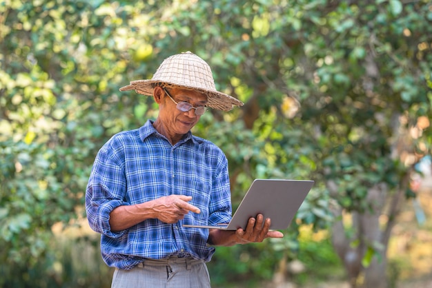 Asiatischer Bauer mit Laptop