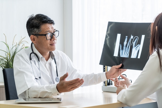 Asiatischer Doktor und Patient besprechen sich