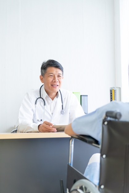 Asiatischer Doktor und Patient besprechen sich