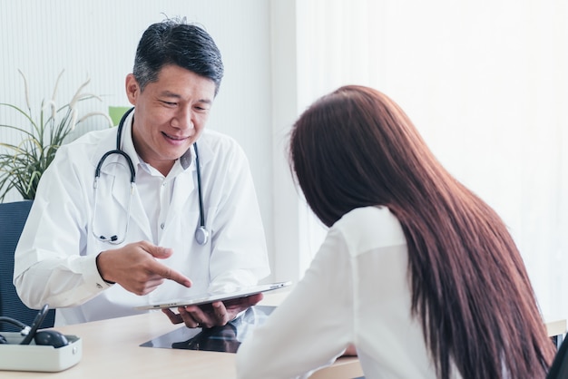 Asiatischer Doktor und Patient besprechen sich