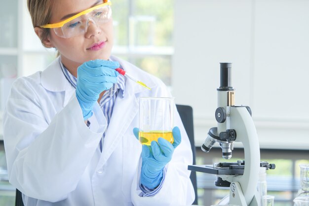 Asiatischer ernster weiblicher Chemiker, der im Labor arbeitet