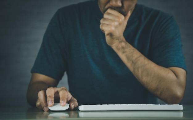 Asiatischer freiberuflicher Mann, der stressige Depressionen hat, traurige Zeit, während er zu Hause an der Laptop-Tastatur-Maus arbeitet