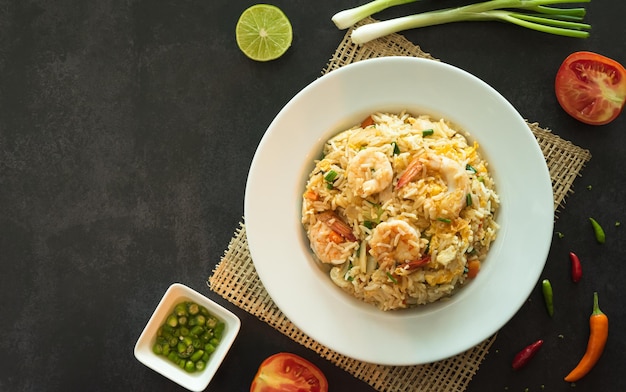 Asiatischer gebratener Reis mit Eiern, Garnelen, Gemüse und Gewürzen, geschlossene Draufsicht mit Platz für Text
