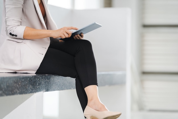 Asiatischer Geschäftsfrauenberuf mit einem digitalen Tablet im Bürokorridor während der Kaffeepause