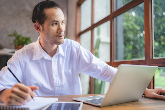 Asiatischer Geschäftsmann freiberuflicher Geschäftsmann, der im Coworking Space oder Café arbeitet