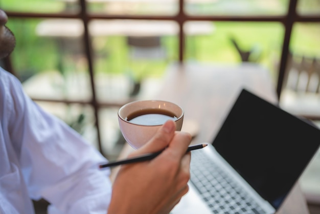 Foto asiatischer geschäftsmann freiberuflicher geschäftsmann, der im coworking space oder café arbeitet