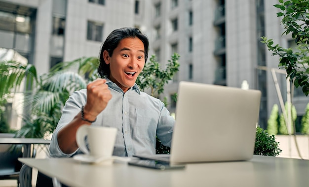 Asiatischer Geschäftsmann in der Stadt. Selbstbewusster junger Mann, der im Café arbeitet.