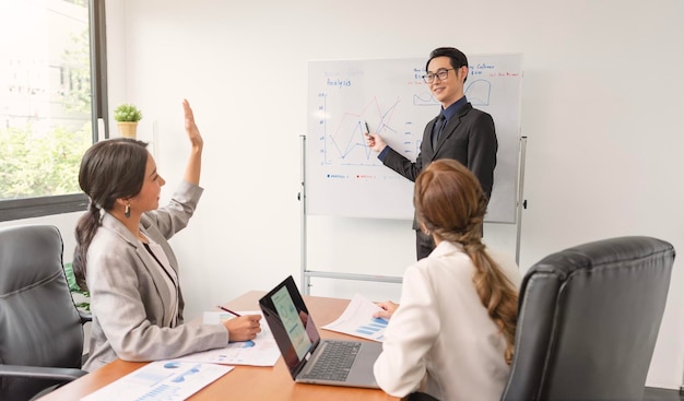 Asiatischer Geschäftsmann präsentiert seine Arbeit Firmenkollegen bei einem Treffen im Büro