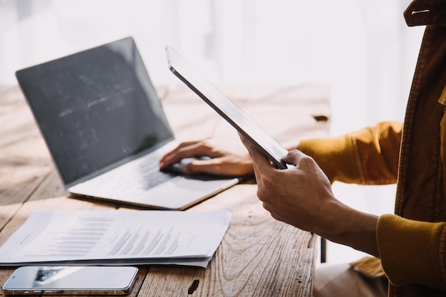 Asiatischer Geschäftsmann und Geschäftsfrau des Unternehmers, die neues Geschäftsprojekt in der Tablette im modernen Meeting im modernen Büro besprechen Asiatisches Business-Casual-Konzept