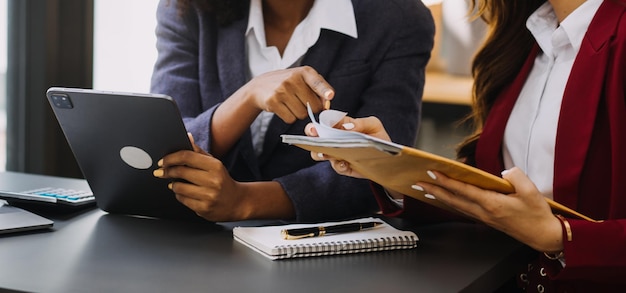 Asiatischer Geschäftsmann und Geschäftsfrau des Unternehmers, die neues Geschäftsprojekt in der Tablette im modernen Meeting im modernen Büro besprechen Asiatisches Business-Casual-Konzept