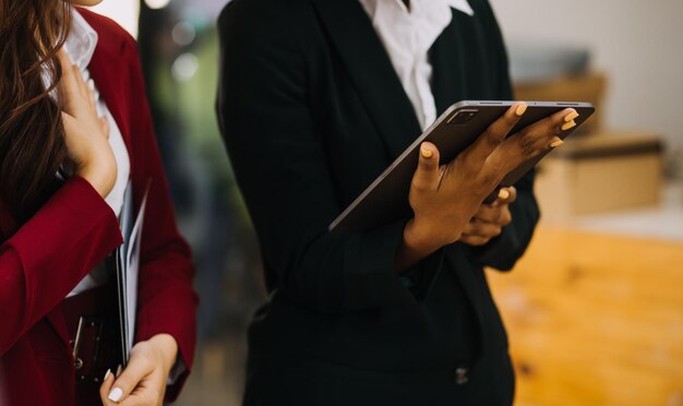 Asiatischer Geschäftsmann und Geschäftsfrau des Unternehmers, die neues Geschäftsprojekt in der Tablette im modernen Meeting im modernen Büro besprechen Asiatisches Business-Casual-Konzept