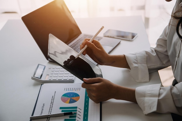 Asiatischer Geschäftsmann und Geschäftsfrau des Unternehmers, die neues Geschäftsprojekt in der Tablette im modernen Meeting im modernen Büro besprechen Asiatisches Business-Casual-Konzept