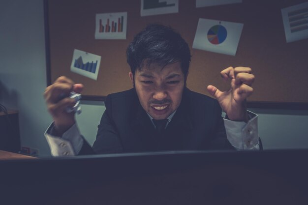 Asiatischer Geschäftsmann unter Stress wegen übermäßiger ArbeitErschöpft fühlenJunger Angestellter hat ein Problem in einem Bürosad Mann von der ArbeitAngry chaotisch Mann Konzept