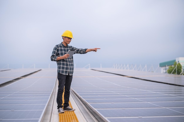 Asiatischer Ingenieur, der auf dem Dach des Solarkraftwerks für die Öko-Umwelt des Steuerstromsystems arbeitet