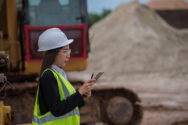 Asiatischer Ingenieur, der auf der Baustelle eines großen Bauprojekts arbeitetThailänderÜberstunden auf der Baustelle