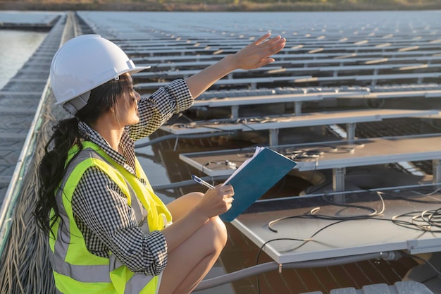 Asiatischer Ingenieur, der auf einem schwimmenden Solarpark arbeitet