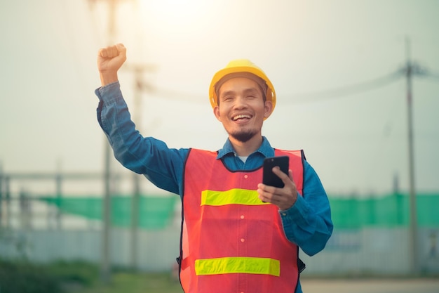 Asiatischer Ingenieur, der im Freien vor Ort steht und zuversichtlich ist, Ingenieurbau, glücklicher Joberfolg bei der Zielplanung