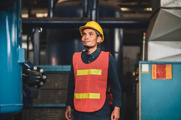 Asiatischer Ingenieur, der Maschinenmaschine in der Fabrik überprüft