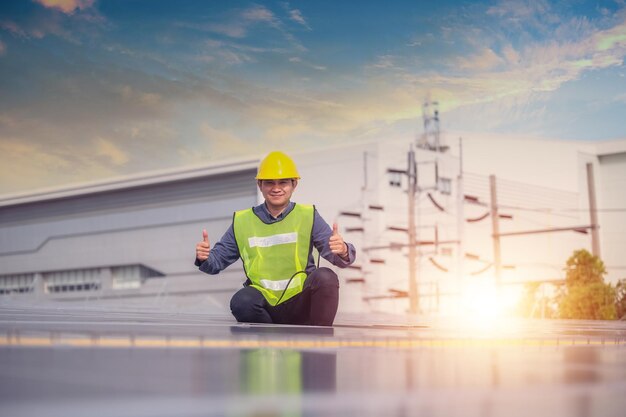 Asiatischer Ingenieur überprüft die Energie von Solarzellen auf dem Dach der Fabrik