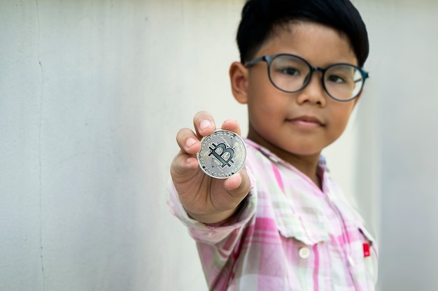 Foto asiatischer junge, der bitcoin hält