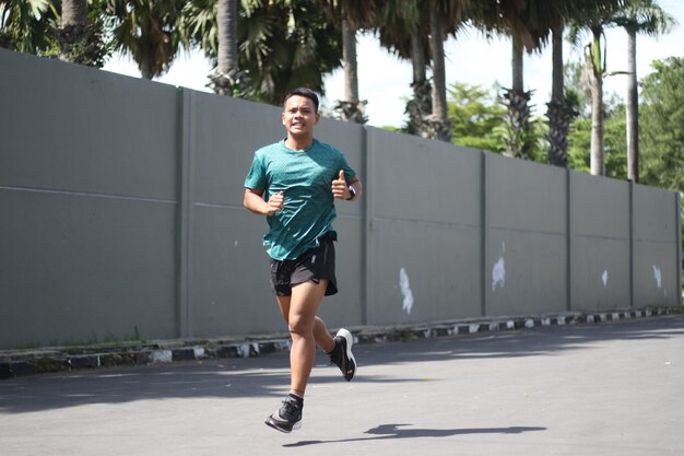 Asiatischer Junge, der sich vor dem Joggen aufwärmt