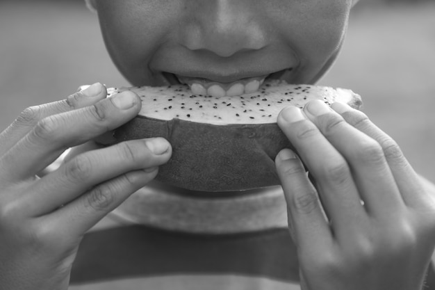 Asiatischer Junge genießen, exotische asiatische Drache-Frucht zu essen.