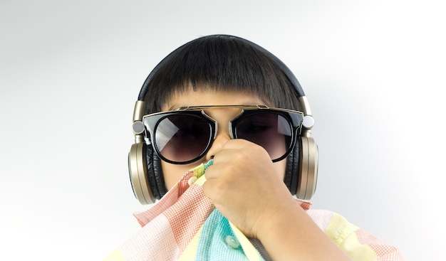 Asiatischer Junge mit Sonnenbrille hört Musik auf Kopfhörer