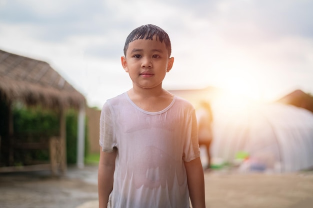 Asiatischer Junge nass im Regen