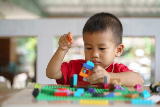 Asiatischer Junge spielt Bausteine