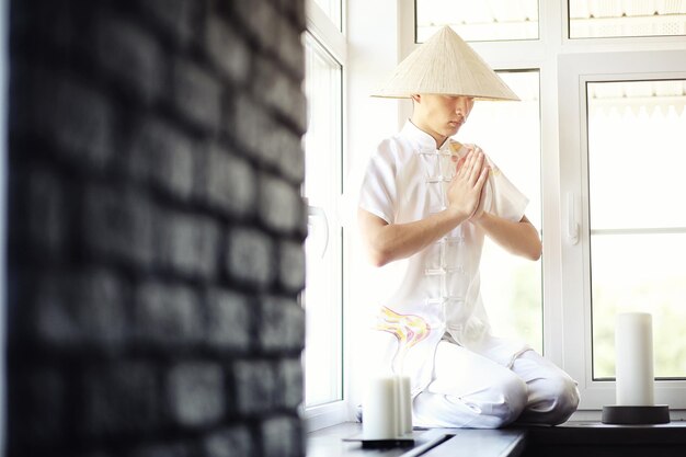 Asiatischer Jungenmönch im Kimono, der ein altes Buch liest