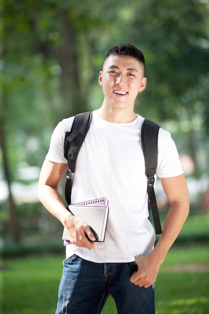 Asiatischer junger hübscher männlicher Student im Freien im Park