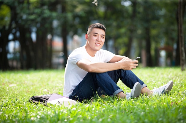 Asiatischer junger hübscher männlicher Student im Freien im Park