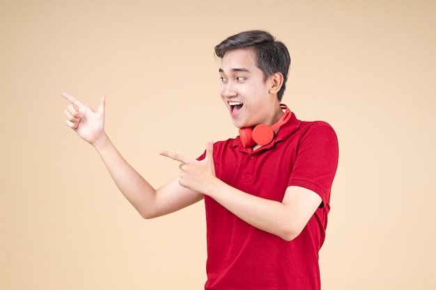 Asiatischer junger hübscher und fröhlicher männlicher Student mit Handgeste