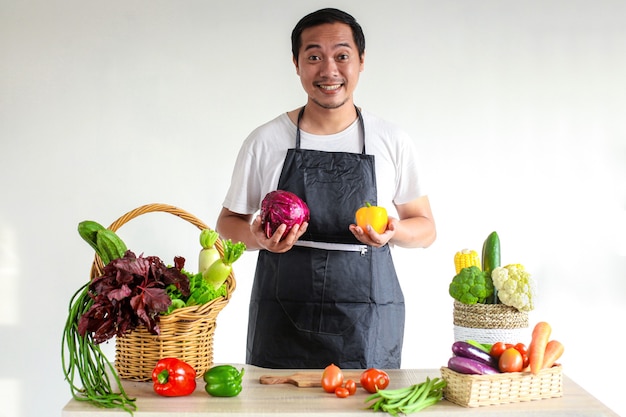 Asiatischer Koch, der Gemüse auf dem Küchentisch zum Kochen zubereitet