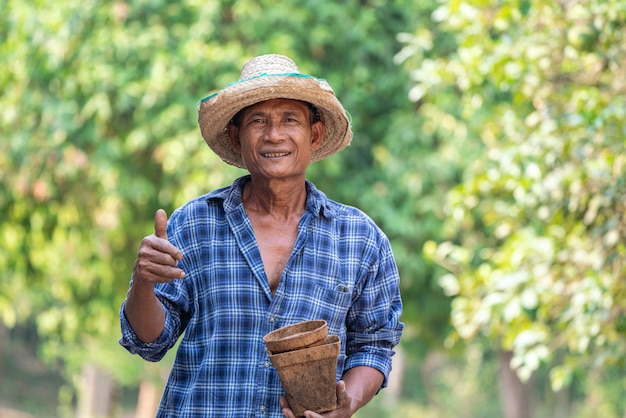 Asiatischer Landwirt, der Topf hält.